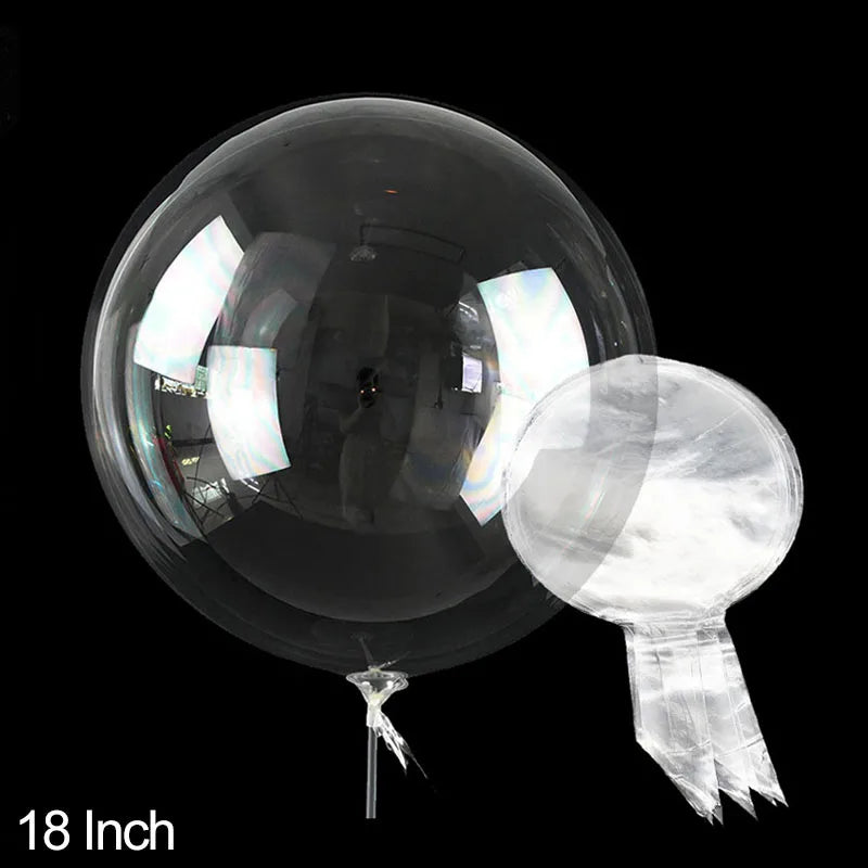 A clear PVC party balloon is shown against a black background, displaying its reflective surface and attached string.