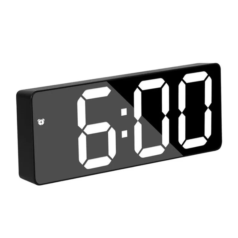 A black digital alarm clock displaying the time 6:00 on a white background.