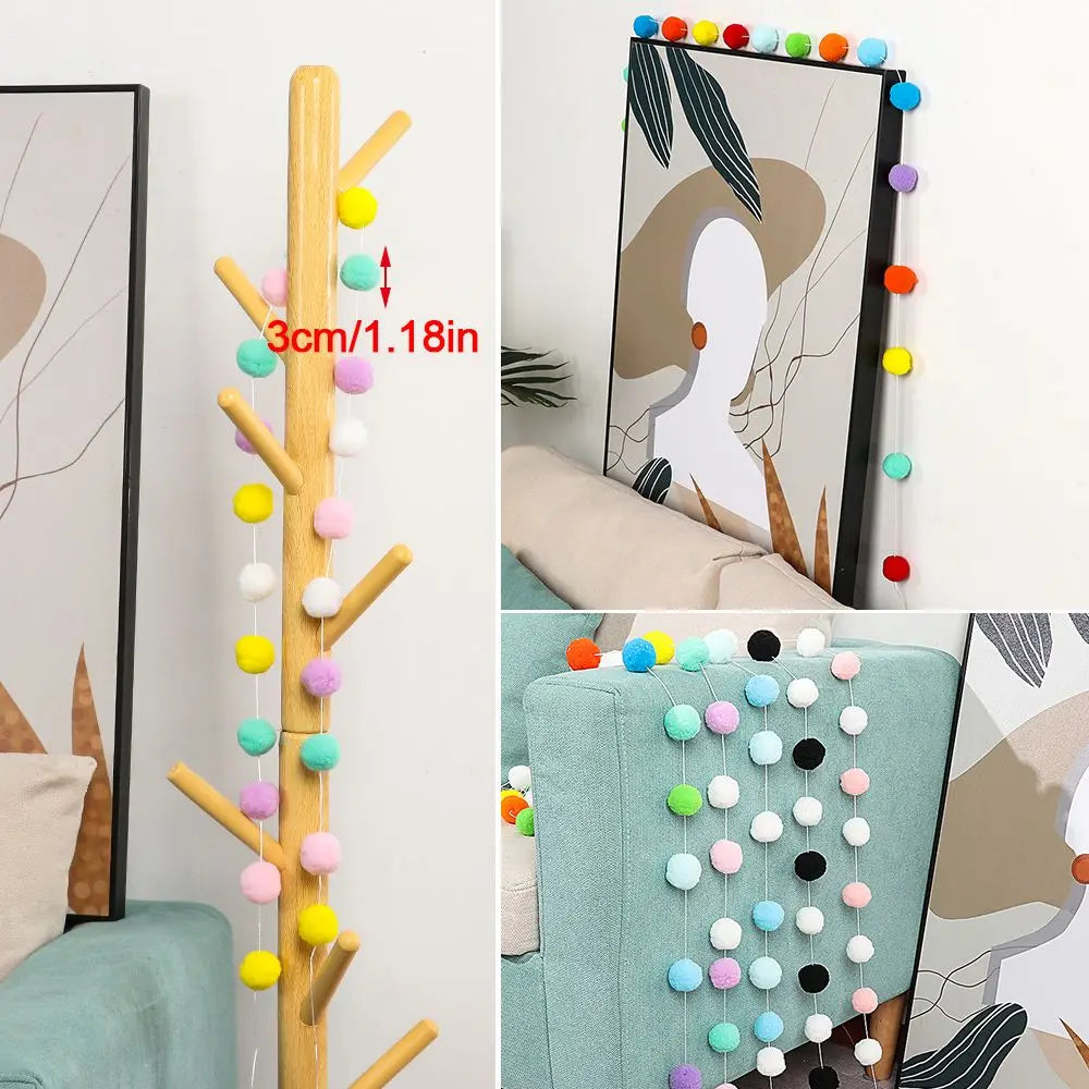 A vertical garland of colorful felt balls in various shades of yellow, green, pink, and white, displayed against a light back