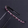 A black crystal rhinestone headband with pink and purple stones is shown against a dark background.