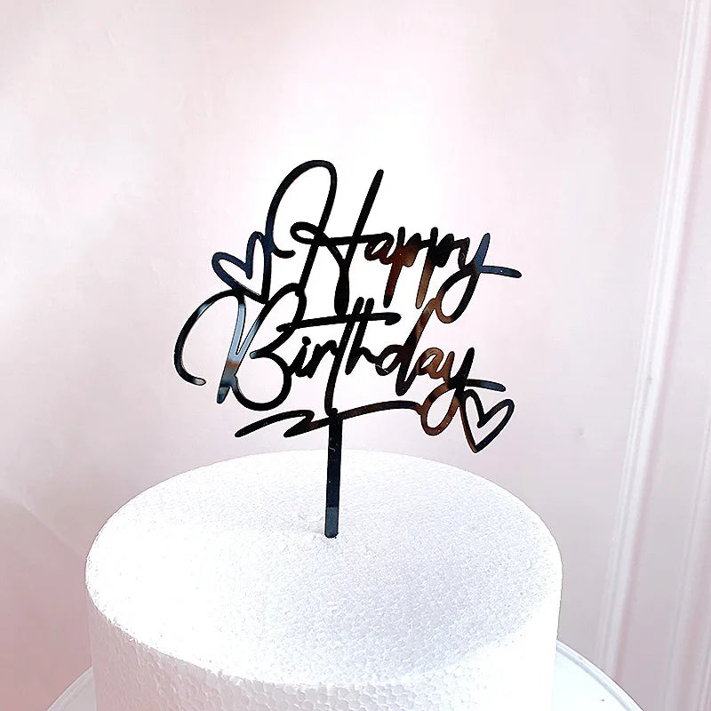 غطاء كعكة عيد ميلاد أكريليك أسود بخط يد يقول 'عيد ميلاد سعيد' على كعكة بيضاء.