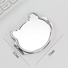 A small, oval, silver-colored folding makeup mirror with a slightly irregular shape is shown on a white background.