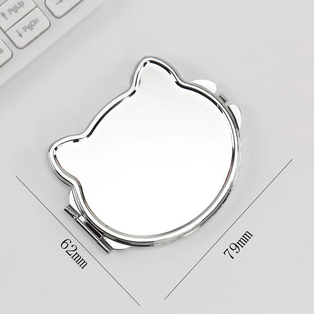 A small, oval, silver-colored folding makeup mirror with a slightly irregular shape is shown on a white background.