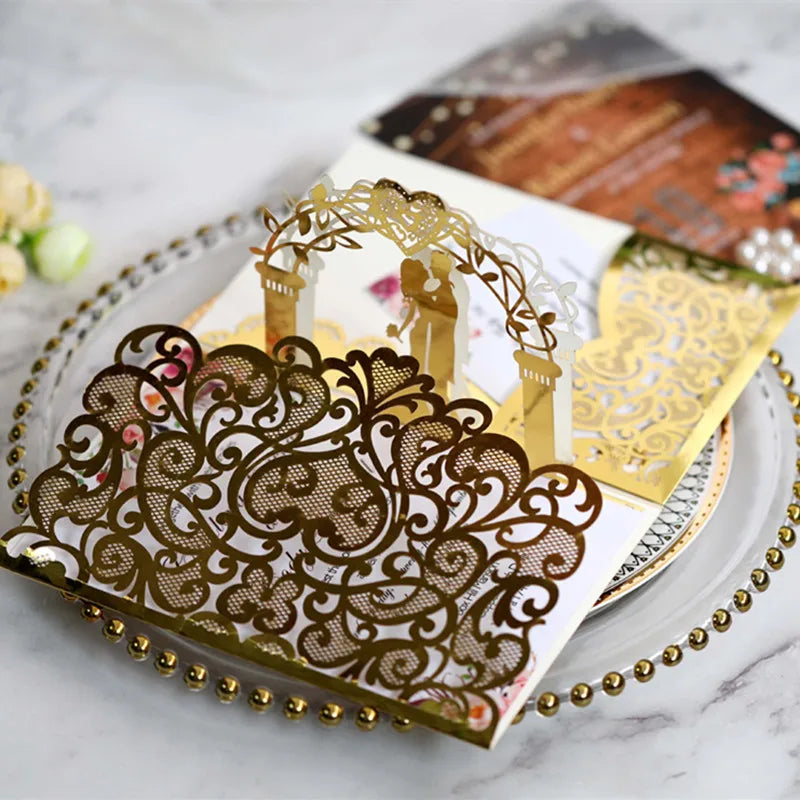 Gold pearl laser cut wedding invitations featuring intricate floral arch designs on white paper