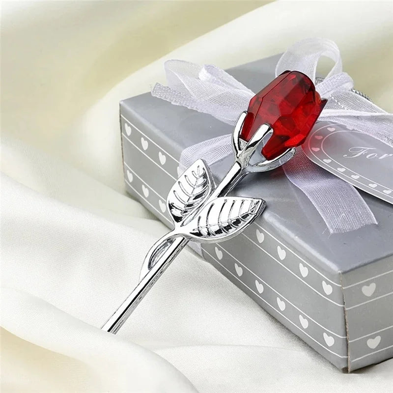 Silver crystal rose artificial flower with a red gemstone set on a gift box