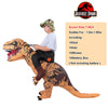 A person is wearing a brown T-Rex inflatable costume with a green patterned hood and black pants.