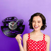 A woman holds a black vinyl record sports car wall clock against a purple background.