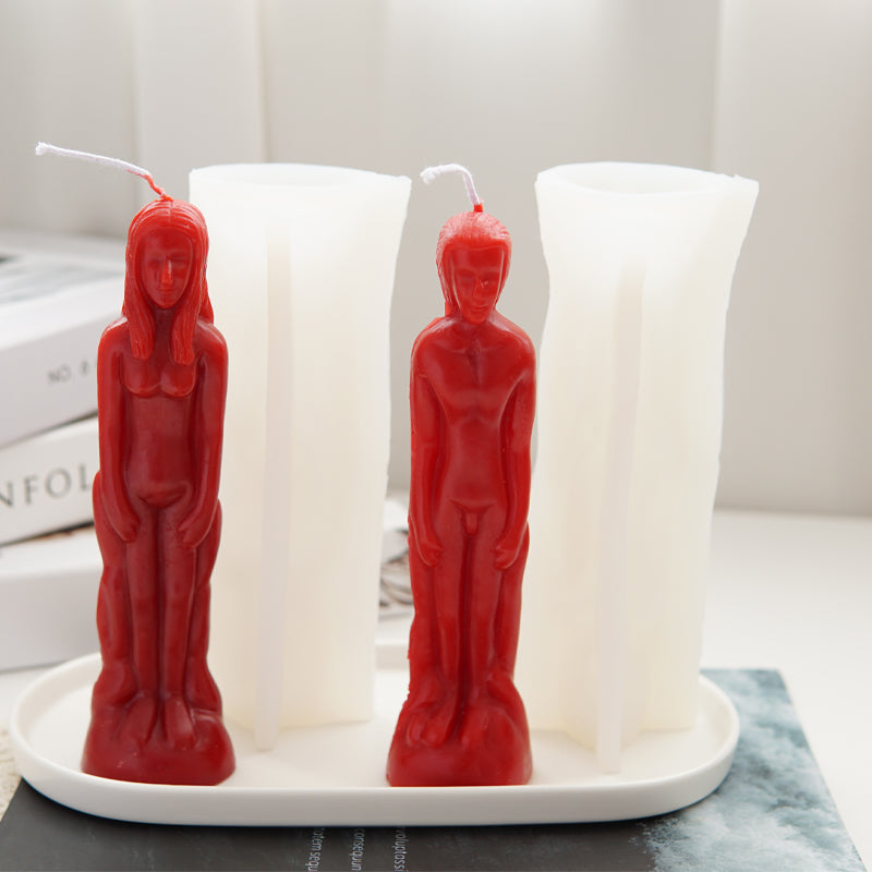 Three realistic human figure silicone molds in red and white are displayed on a white plate.
