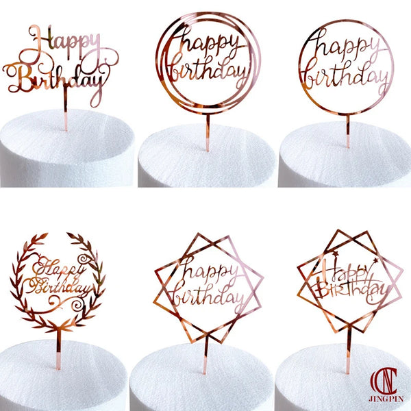 Rose gold acrylic happy birthday cake toppers in various designs on white cake boards