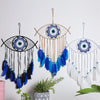 Handmade boho evil eye dream catcher wall decor featuring blue and white feathers and beads