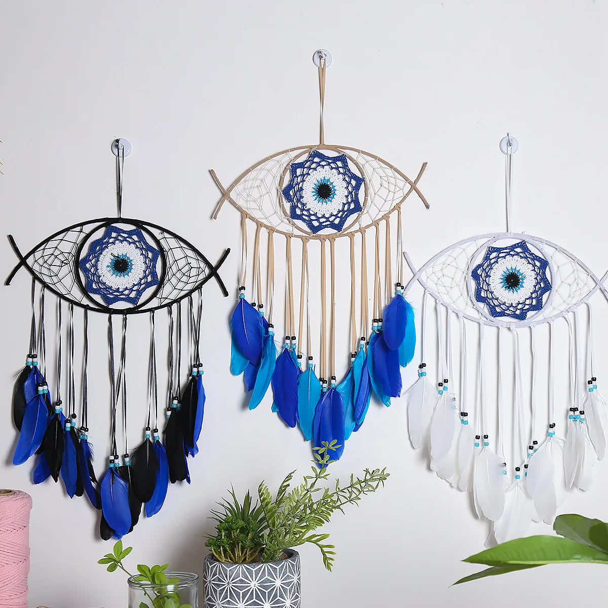 Handmade boho evil eye dream catcher wall decor featuring blue and white feathers and beads