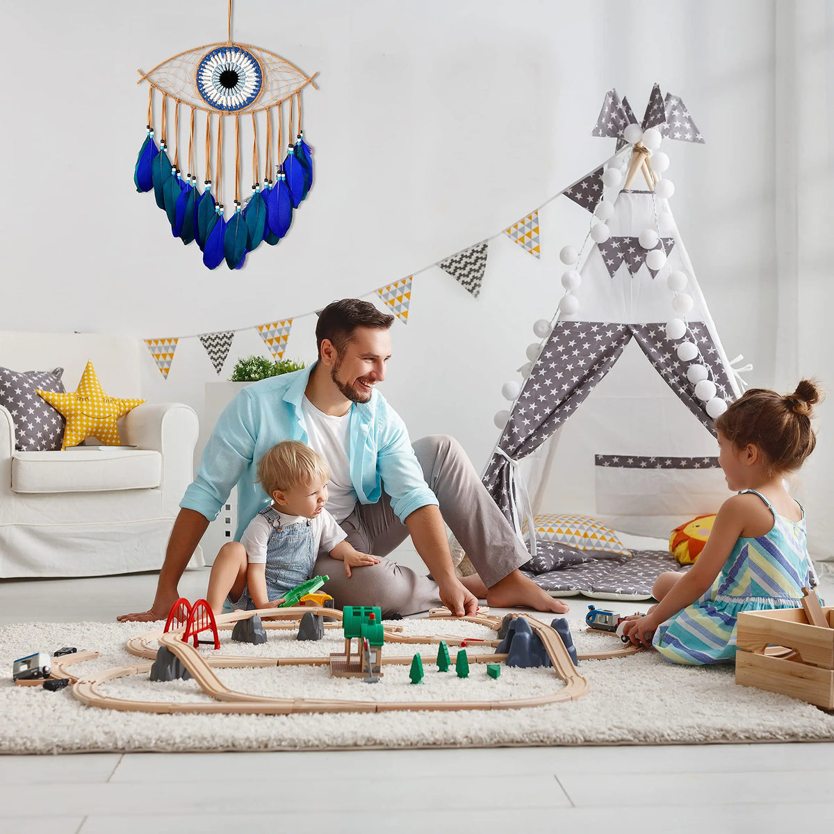 A father and child play with wooden toys in front of a handmade boho evil eye dream catcher wall decor.