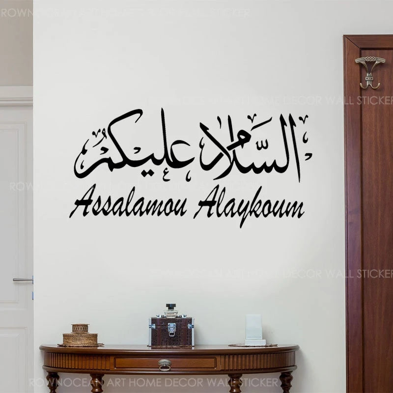 Black Arabic calligraphy of Assalamu Alaykum written on a white wall.