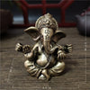 Handcrafted bronze statue of Ganesha with multiple arms sitting in a meditative pose