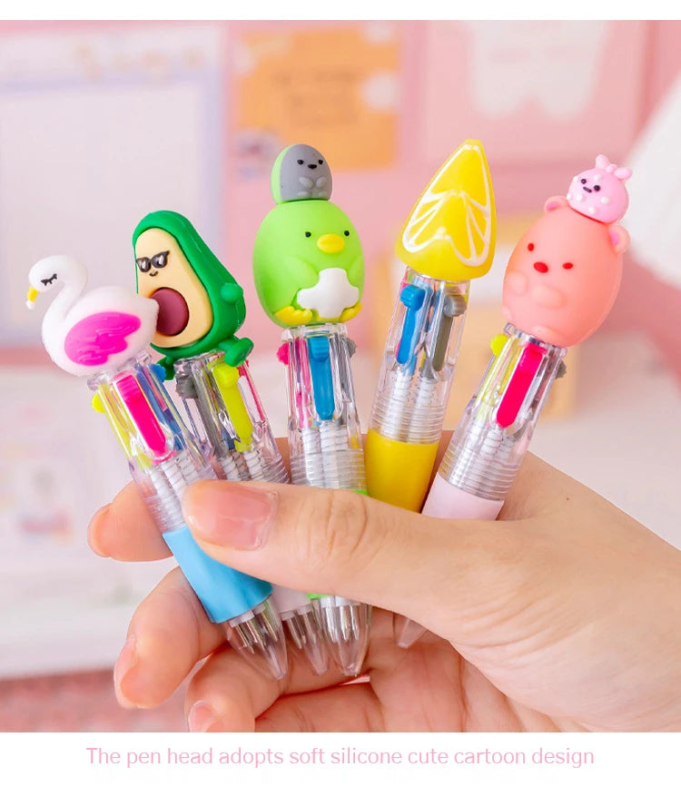 A hand holds a set of five colorful silicone cartoon-designed pen heads featuring animals like a bird, a frog, and a pink bir
