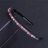 A black headband decorated with colorful crystal and rhinestone embellishments.