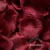 A close-up of deep red silk rose petals arranged for weddings and events.