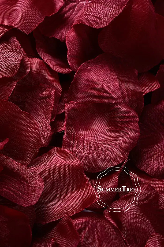 A close-up of deep red silk rose petals arranged for weddings and events.