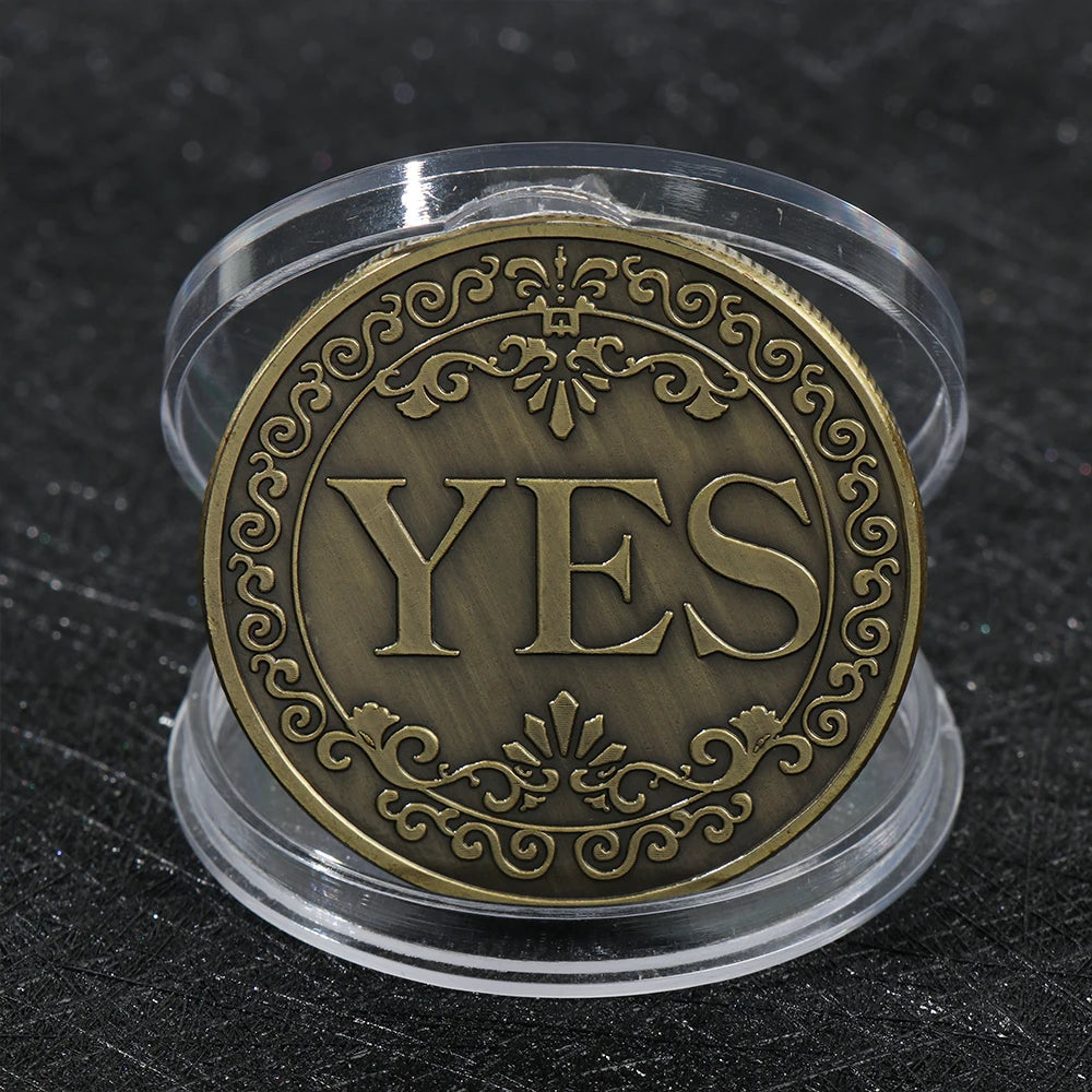 Moneda de metal dorada redonda con la palabra SÍ grabada, en un soporte de plástico transparente.
