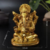 A golden handcrafted resin statue of Lord Ganesha sitting in a meditative pose.