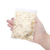 A hand holds a clear plastic bag filled with shiny gold foil flakes for resin art and jewelry making