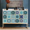 A display of square mandala tile stickers in various shades of blue and teal arranged on a wooden shelf.