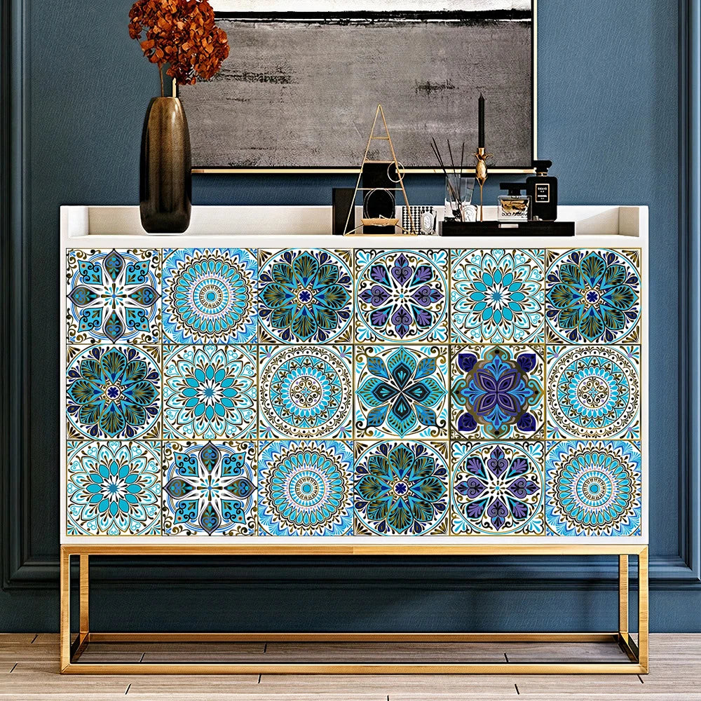 A display of square mandala tile stickers in various shades of blue and teal arranged on a wooden shelf.