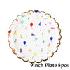 A white plate decorated with colorful paper party balloons and small paper food items for a children's event.