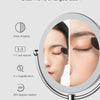 A wall-mounted LED makeup mirror showing clear front and enlarged back with 1:1 real restore and 360 degree rotation features