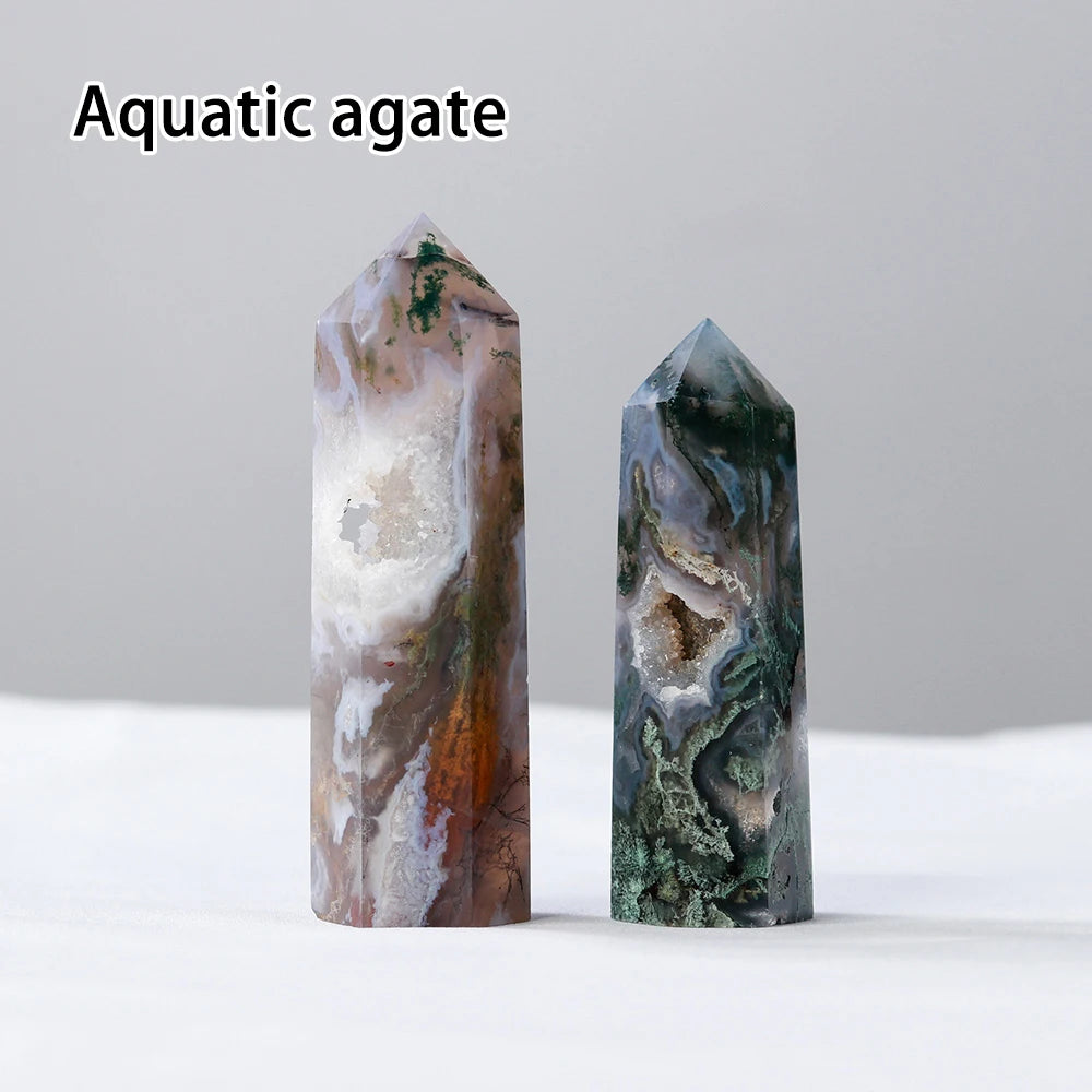 Two natural aquatic agate crystal points displayed on a white surface.