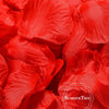 A close-up of vibrant red silk rose petals used for weddings and events.
