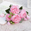 A bouquet of pink silk rose and peony artificial flowers displayed on a white surface.