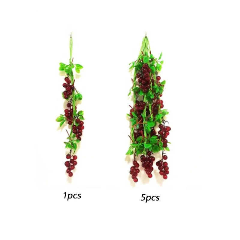 Two arrangements of artificial red berries and green leaves for decoration