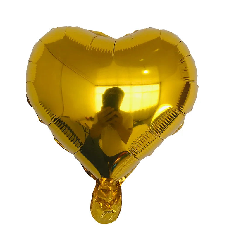 Goldfarbener herzförmiger Folienballon mit einer reflektierten Person drinnen