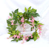 Green silk wisteria garland vine with pink flowers used for weddings and home decor