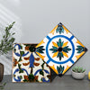A square tile sticker featuring a blue and yellow floral design on a white background