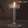 Elegant glass candle holder with a lit candle on a clear glass base.