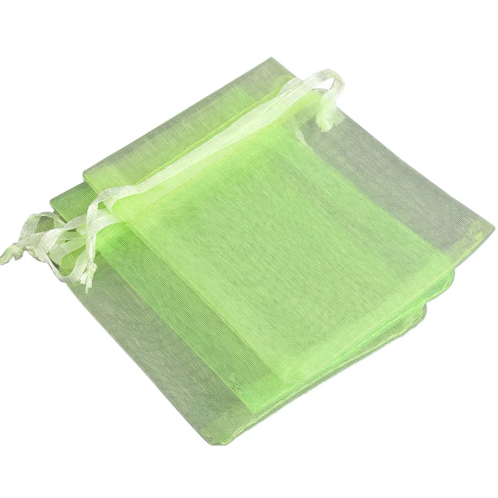 A stack of light green organza drawstring gift pouches for jewelry, candy, or party favors.