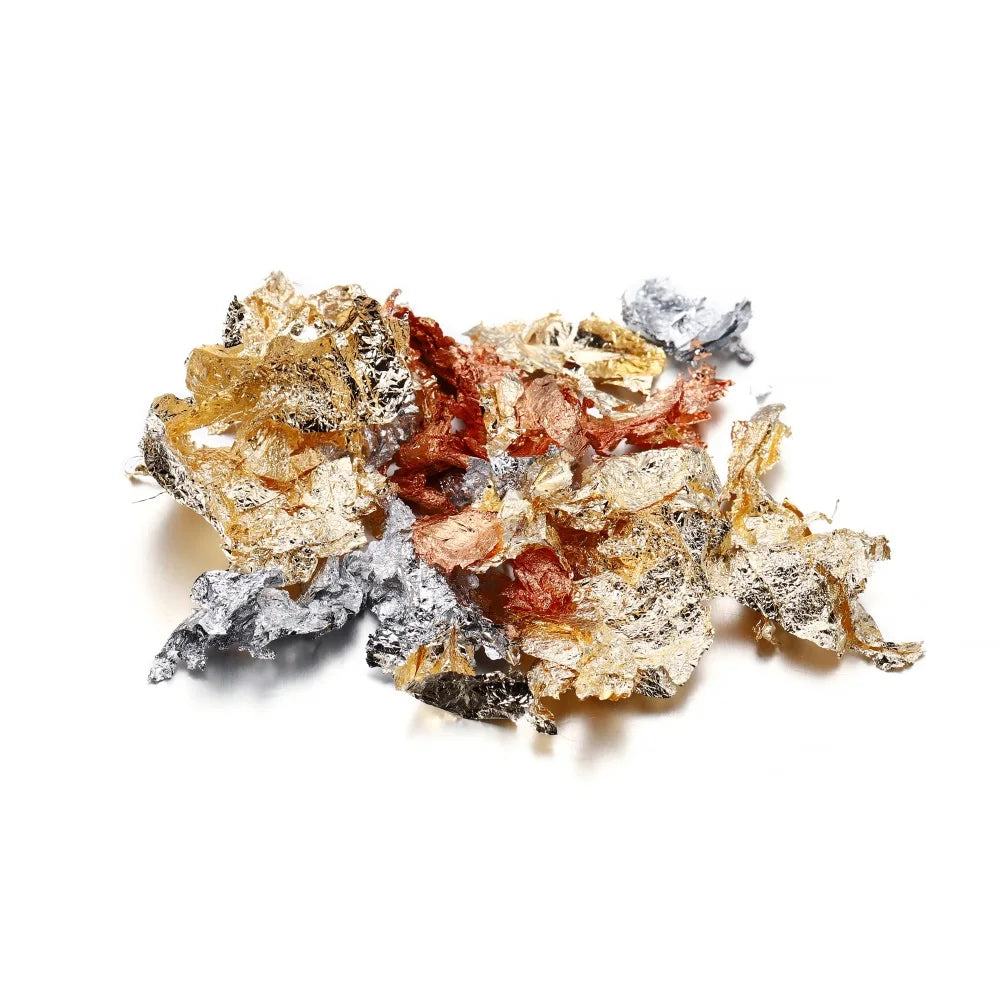 A pile of shiny gold foil flakes mixed with silver and reddish-brown flakes for resin art.