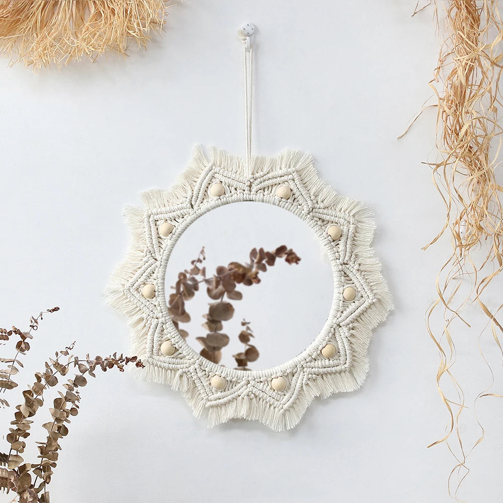 Boho macrame round wall mirror with a textured frame and natural wood accents hanging on a white wall.