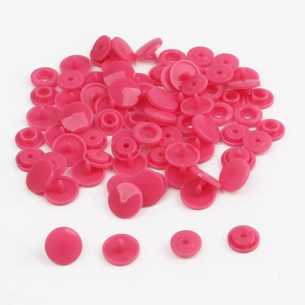 A pile of assorted pink snap buttons, measuring 12mm and 10.5mm, for crafting.