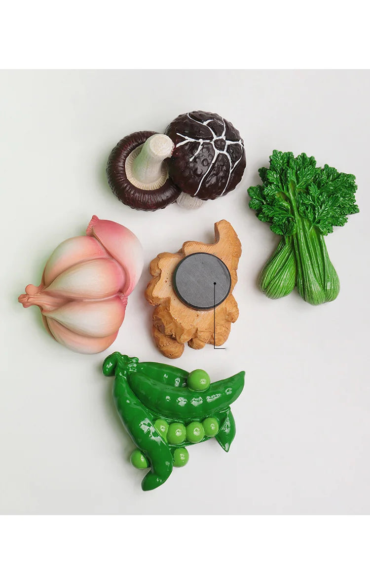 A set of realistic fruit and vegetable fridge magnets including a dark plum, a pink onion, a green broccoli floret, and a gre