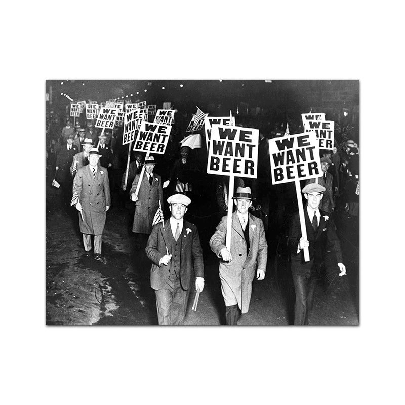 A black and white photograph of several men holding signs that read We Want Beer in a vintage Prohibition-era setting.