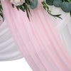 Pink sheer chiffon fabric drape with green foliage and white roses used for wedding or event decor