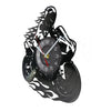 A black wall clock shaped like a motorcycle rider, featuring a vinyl record design and a clock face.