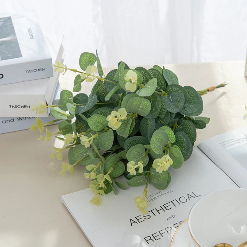 A bundle of green eucalyptus leaves with small yellow stems used for home and event decor.