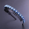 A sparkling blue crystal rhinestone headband with black metal detailing is shown against a dark background.