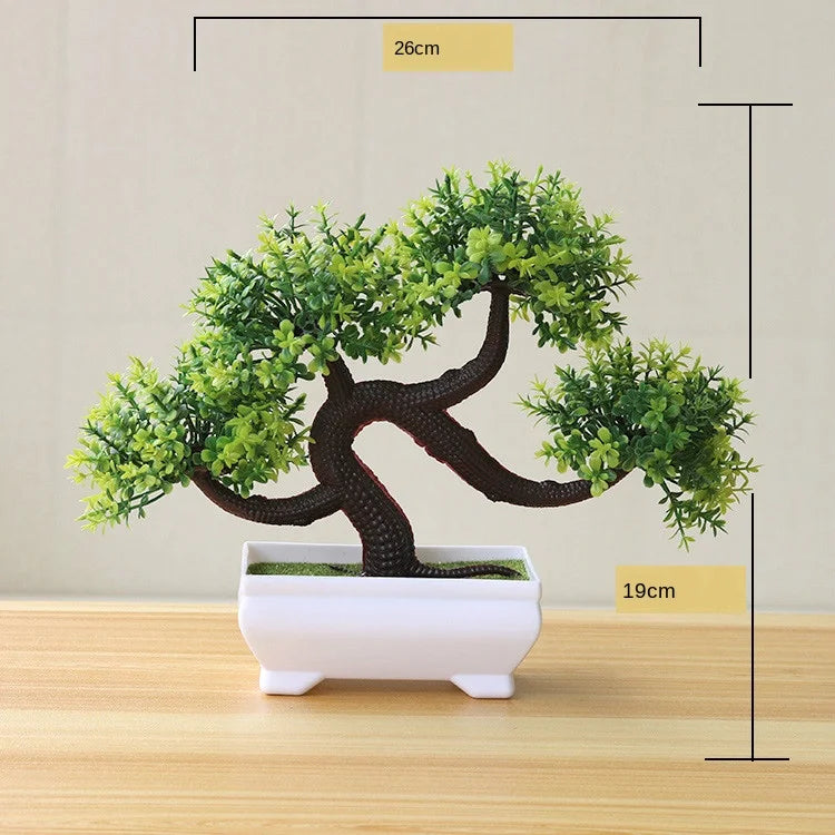 Artificial bonsai tree in a white pot with green foliage displayed on a wooden surface.