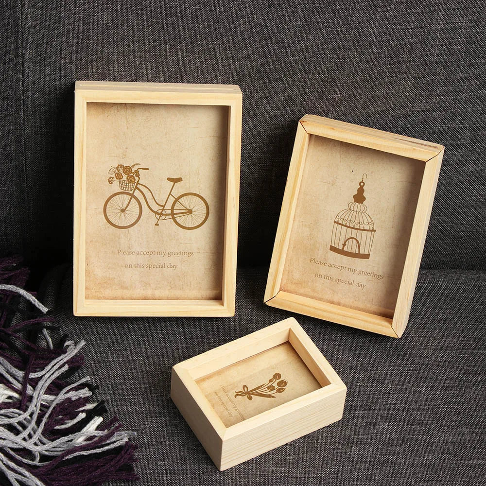 A set of three vintage wooden photo frames featuring botanical and bicycle illustrations on a dark gray background.