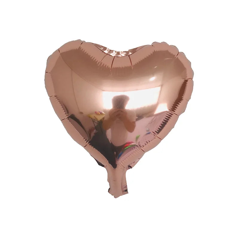 Herzförmiger Folienballon, der eine Person im Hintergrund reflektiert.
